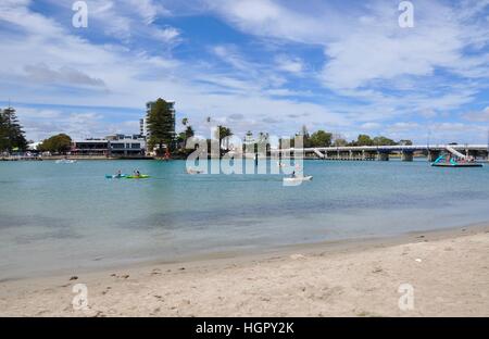 Mandurah,WA,Australia-March 7,2014:persone fare kayak in Mandurah estuario, scorza di ingresso, con spiaggia, bridge e fabbricati in Australia Occidentale Foto Stock