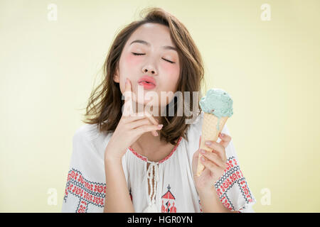 Ritratto di giovane donna con capelli bobbed holding gelato chiudendo gli occhi Foto Stock