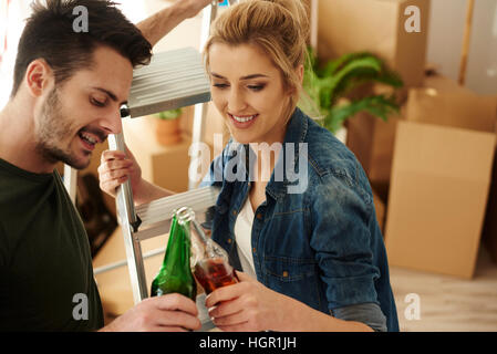 Coppia giovane la tostatura la birra nella nuova casa Foto Stock