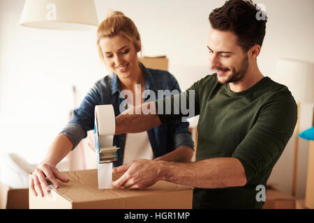 L'uomo la nastratura scatola di cartone per spostare Foto Stock
