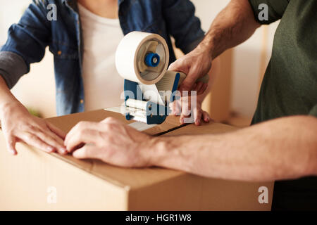 Close up di mani umane cartoni di incollaggio Foto Stock