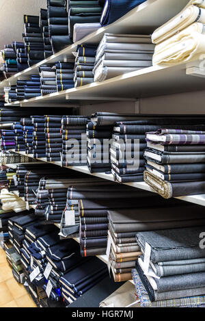 Rotoli di tessuti e prodotti tessili in un negozio della fabbrica. Multi colori e motivi diversi sul mercato. Foto Stock