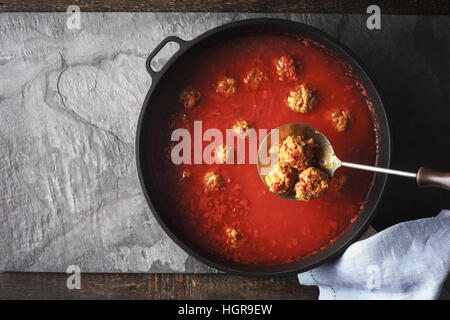 Polpette con la salsa di pomodoro in padella su sfondo di pietra Foto Stock