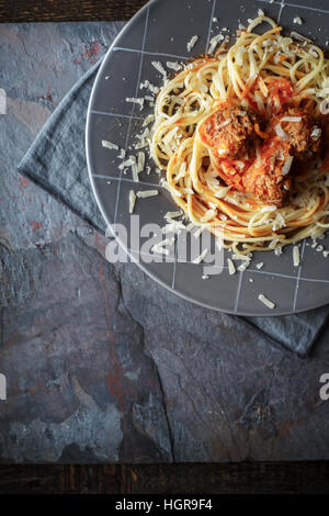 Spaghetti con polpette nella lastra grigia sulla pietra verticale di sfondo Foto Stock