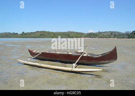 Pirogue poste in posizione di riposo sulle rive del Ambatozavavay in Nosy Be, Madagascar Foto Stock