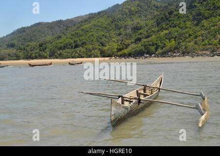 Pirogue poste in posizione di riposo sulle rive del Ambatozavavay in Nosy Be, Madagascar Foto Stock