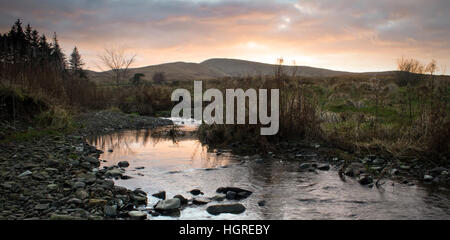 Tramonto su un fiume cercando di colline fuori Ravenstonedale, Cumbria Foto Stock