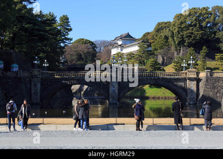 I visitatori di scattare foto del Seimon-Tetsubashi (Main Gate Bridge) di Tokyo Imperial Palace, il 12 gennaio 2017, Tokyo, Giappone. Il governo giapponese è discutere i cambiamenti giuridici per consentire l'abdicazione dell'Imperatore Akihito (83 anni) e l'Ascensione al trono di suo figlio primogenito del Principe Ereditario Naruhito sul primo giorno del nuovo anno 2019. Questo sarebbe il trentesimo anno di Akihito del regno. Corrente legge giapponese non ha alcuna disposizione per consentire un imperatore a passo basso, ma vi è il sostegno pubblico per Akihito a farsi da parte dopo un indirizzo pubblico nel 2016 dove ha espresso preoccupazione per il fatto che la sua età può fermare lui f Foto Stock