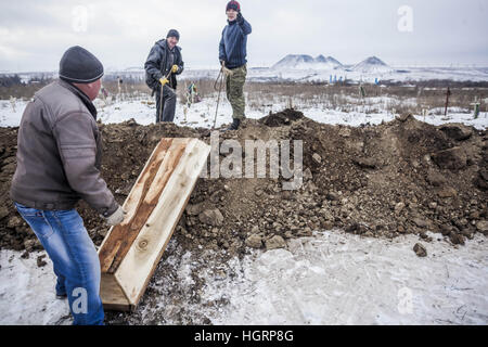 Makiivka, Donetsk Oblast, Ucraina. 27 Dic, 2016. Lavoratori portano una bara con un Donetsk del popolo soldato Repubblica uccisi negli ultimi combattimenti in Debaltseve, prima della sua sepoltura in un cimitero Makiivka, Ucraina. © Celestino Arce/ZUMA filo/Alamy Live News Foto Stock