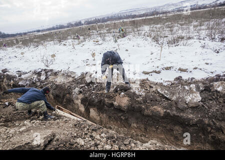 Makiivka, Donetsk Oblast, Ucraina. 27 Dic, 2016. Lavoratori seppellire una bara con Donetsk del popolo soldato Repubblica uccisi negli ultimi combattimenti in Debaltseve, in un cimitero Makiivka, Ucraina. © Celestino Arce/ZUMA filo/Alamy Live News Foto Stock