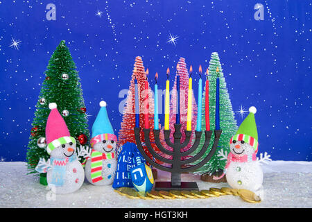 Il Menorah e rosso, rosa, verde di pini con pupazzo di neve sulla neve in similpelle di sfondo blu puntini bianchi e stelle. Natale e Hanukkah insieme. Multi fede Foto Stock