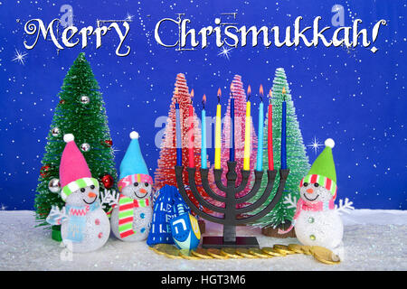 Il Menorah e rosso, rosa, verde di pini con pupazzo di neve sulla neve in similpelle di sfondo blu puntini bianchi e stelle. Natale e Hanukkah insieme. Multi fede Foto Stock