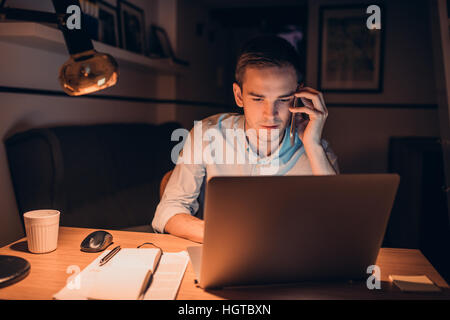 Giovane imprenditore in un duro lavoro di sera tardi Foto Stock