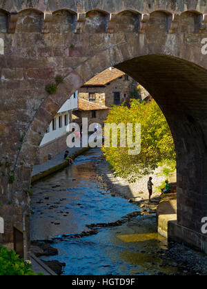 Il fiume Quiviesa in esecuzione sotto San Cayetano bridge nella città medievale Potes in Picos de Europa Cantabria Spagna settentrionale Foto Stock