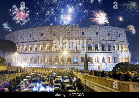 Una folla di persone a piedi e in auto, si radunano davanti al Colosseo per festeggiare l arrivo del nuovo anno con fuochi d'artificio Foto Stock