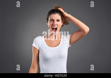 Una giovane e bella donna urlando furiosamente. Foto Stock