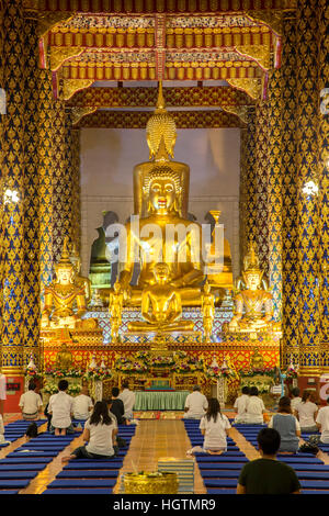 Statua di Buddha e adoratori, sala da preghiera, Wat Suan Dok, Chiang Mai, Thailandia Foto Stock