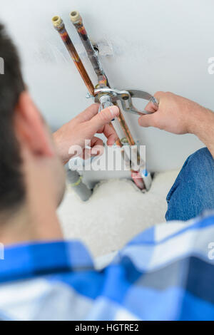 L uomo del dado di serraggio sul tubo di rame Foto Stock