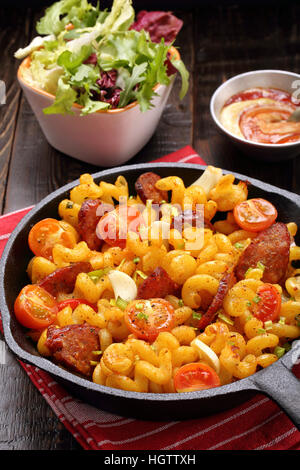 Casseruola con il salame chorizo in una padella su sfondo di legno Foto Stock