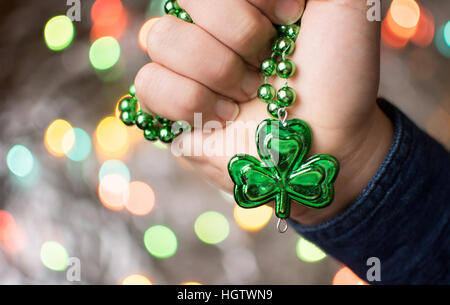 Maschio di mano azienda green girocollo clover. Il giorno di San Patrizio preparazione Foto Stock