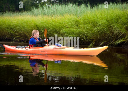 Un uomo in kayak in basso, porzione di marea del fiume Taunton in Dighton, Massachusetts. Recentemente indicata una selvaggia e Scenic River. L'estate. Foto Stock