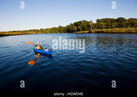 Un uomo in kayak in basso, porzione di marea del fiume Taunton in Dighton, Massachusetts. Recentemente indicata una selvaggia e Scenic River. L'estate. Foto Stock