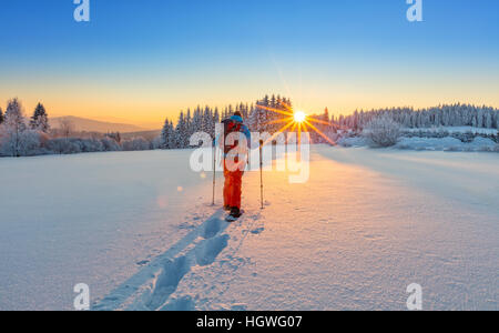 Escursioni con le racchette da neve walker in esecuzione in polvere di neve con bellissima alba luce. Outdoor attività invernali e uno stile di vita sano Foto Stock