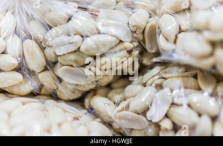 Raw arachidi sgusciate in sacchetti di plastica per la vendita Foto Stock