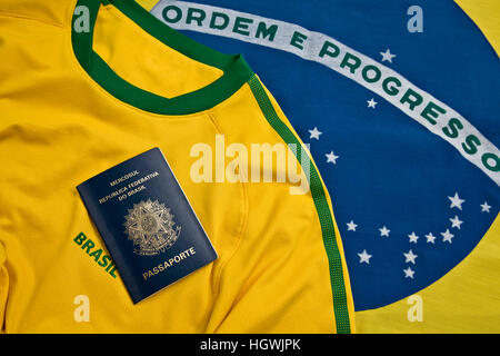 Passaporto brasiliano oltre un brasiliano jersey e flag Foto Stock