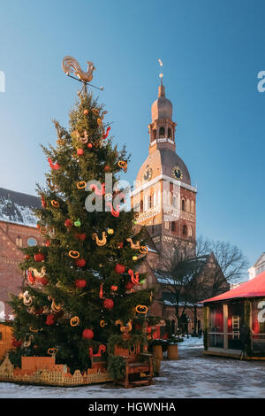 Mercatino di Natale in Piazza Duomo con il Duomo di Riga nella cattedrale di Riga, Lettonia. Albero di natale e case commerciali con vendita di regali di Natale, dolci un Foto Stock