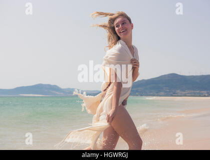 Giovane donna felice in spiaggia. Tarifa, Costa de la Luz, Cadice, Andalusia, Spagna. Foto Stock