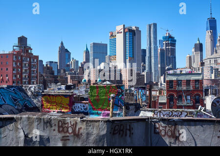 Un sacco di graffiti sui tetti visto da Manhattan Bridge con grattacieli e il World Trade Centre in background Foto Stock