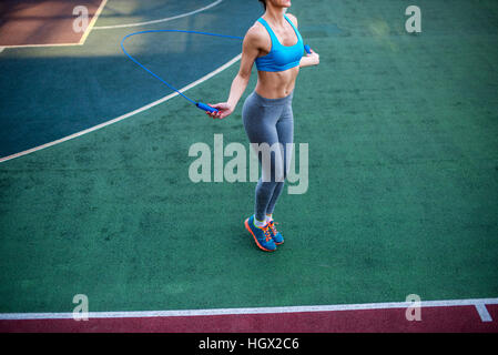 Athletic donna utilizzando salto con la corda per il loro allenamento su un Stadium Foto Stock