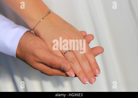 Lo sposo tiene la sposa la mano con un anello di close-up Foto Stock