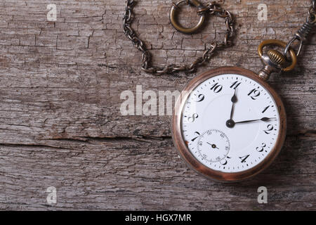 Oro vecchio orologio da tasca su una catena su un vecchio tavolo di legno vicino fino Foto Stock