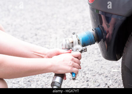 Auto alla stazione di gas essendo riempito con carburante Foto Stock