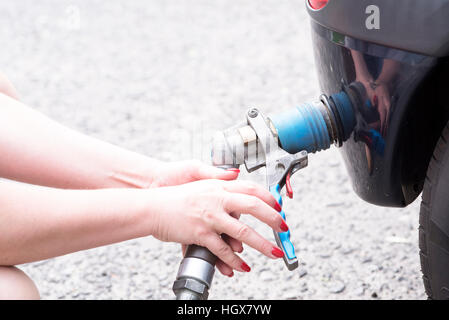 Auto alla stazione di gas essendo riempito con carburante Foto Stock