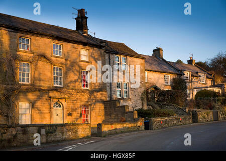 Regno Unito, Inghilterra, Derbyshire, Ashford nell'acqua, Ciccioli Lane, inverno, la mattina presto la luce del sole sulle case, Gritstone House Foto Stock