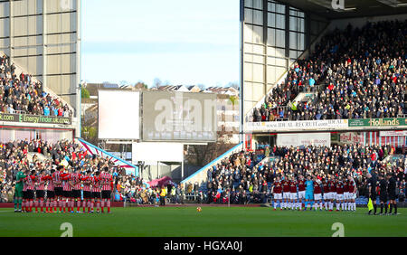 Giocatori e appassionati di osservare un minuto di silenzio per Graham Taylor scomparso questa settimana prima della Premier League a Turf Moor, Burnley. Foto Stock