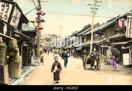 Giappone, Yokohama. Cartolina Vintage colorate a mano. Noga street, costruzioni in legno, negozi. La gente camminare, costumi tradizionali. Foto Stock