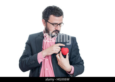 L'uomo tirando fuori un cuore rosso dalla tasca della sua tuta Foto Stock