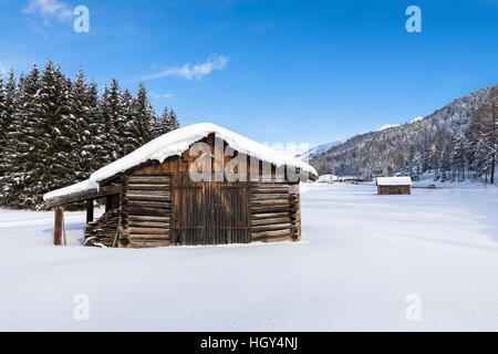 Snow covered wooden chalet in a white winter landscape Foto Stock