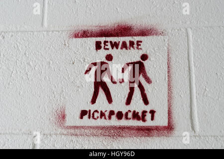 Pickpocket cartello segnaletico impresse su di un muro bianco Foto Stock