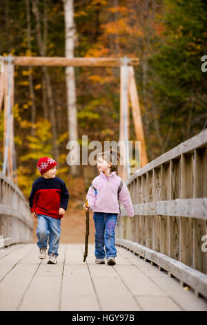 Un giovane fratello e sorella (di età compresa tra 4 e 6) escursione su di un ponte di sospensione in New Hampshire White Mountain National Forest. Lincoln Woods Trail. Modello Foto Stock