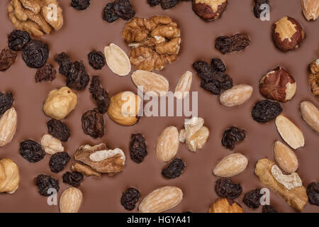 Cioccolato al latte con sfondo con noci e uvetta Foto Stock