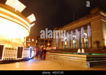 "Gallopers' Fairground Ride in pieno svolgimento accanto alla festosa City Hall (r) al tempo di Natale nel centro della città di Sheffield, Yorkshire Regno Unito Foto Stock