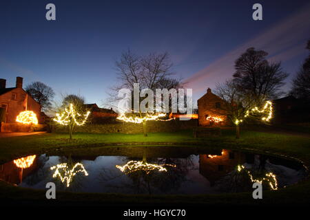 Le luci di Natale intorno al laghetto sul verde in Foolow, Parco Nazionale di Peak District, Derbyshire, England, Regno Unito Foto Stock