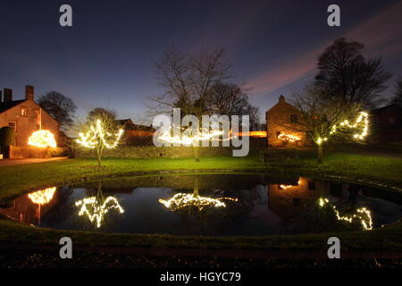 Le luci di Natale intorno al laghetto sul verde in Foolow, Parco Nazionale di Peak District, Derbyshire, England, Regno Unito Foto Stock