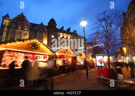 Gli acquirenti di festa sfoglia merci nella cute di cabine di legno al mercatino di Natale sulla Fargate, centro della città di Sheffield nello Yorkshire, Inghilterra Foto Stock
