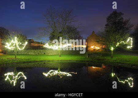 Le luci di Natale intorno al laghetto sul verde in Foolow, Parco Nazionale di Peak District, Derbyshire, England, Regno Unito Foto Stock